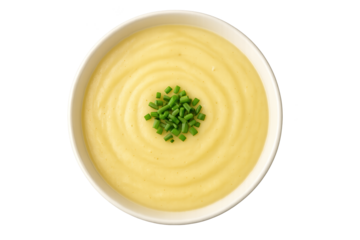 Creamy yellow sauce in white bowl with chopped chives garnish, top-down view