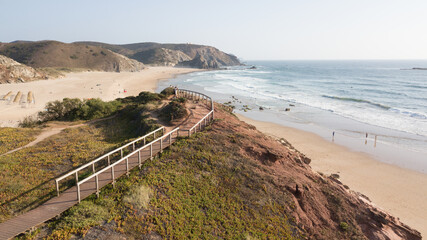 Wooden boardwalk leading to praia da amoreira beach in aljezur, portugal
