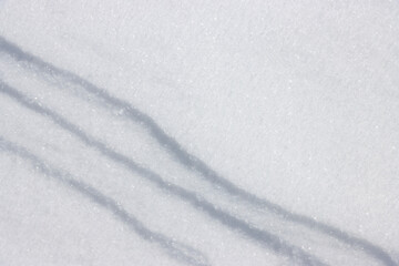 Three diagonal straight lines in fresh white snow