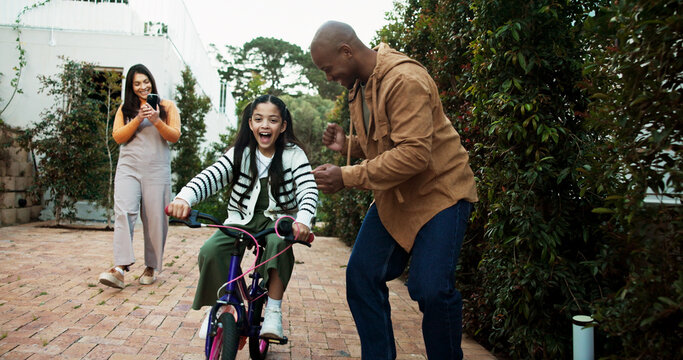 Parents, bicycle and girl with learning, celebration or recording video with phone, memory and bonding. People, mother and father with child, smartphone or photography for teaching with goals on bike