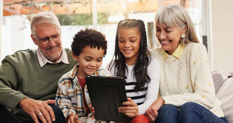Tablet, relax and grandparents with kids on sofa in home for watching movie, series or show. Happy, digital technology and senior people with children for streaming film together in living room.