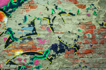 Abstraction of crumbling graffiti on a city street wall. Colorful abstract background. Old, cracked, peeling paint on the wall as a background.