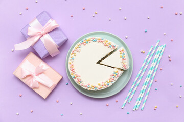 Plate with sweet bento cake and gift boxes on lilac background