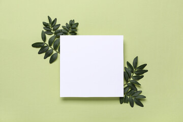 Blank card with fresh green leaves on color background