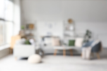 Stylish interior of living room with grey sofas and armchair, blurred view