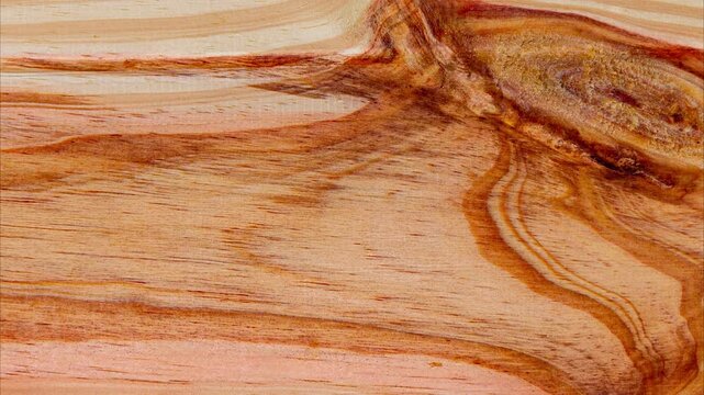 Close-up of natural pine wood texture with grain pattern and knot in motion