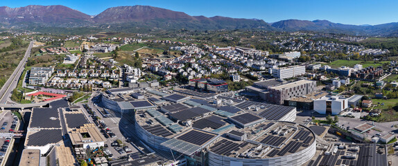 Aerial panorama of Tirana’s eastern district showing solar-powered rooftops, modern developments, and scenic green surroundings.
