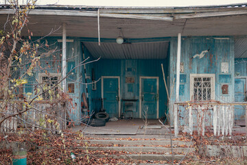 Old abandoned wooden house boat station blue color.