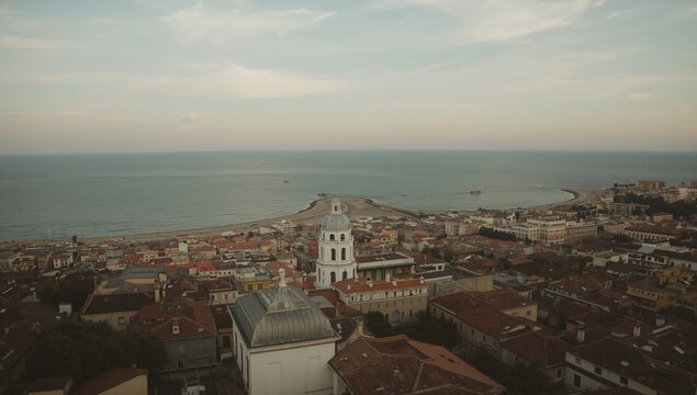 Aerial perspective of a coastal town with vintage architecture overlooking the ocean, historical charm