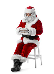 Santa Claus with letters sitting on white background