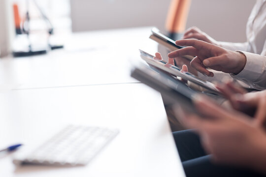 business professionals using digital tablets and smartphones in modern office workspace