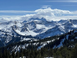 Obraz premium Spring snow on mountain peaks in the Swiss Alps above the tourist resort of Sörenberg, Switzerland - Frühlingsschnee auf Berggipfeln in den Schweizer Alpen oberhalb des Ferienortes Sörenberg, Schweiz