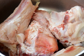 several pieces of raw beef bones in a pot, being prepared for making bone broth, bone marrow soup...