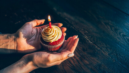 Female Hands Holding Red Velvet Cupcake With Lit Birthday Candle