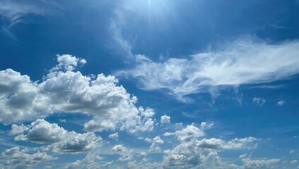 Obraz premium Beautiful sky filled with fluffy white clouds under bright sunlight, ideal for outdoor activities