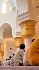 Group of Muslim men praying inside a grand mosque with golden columns and arched designs. A serene spiritual moment reflecting devotion, peace, and the essence of Islamic faith.