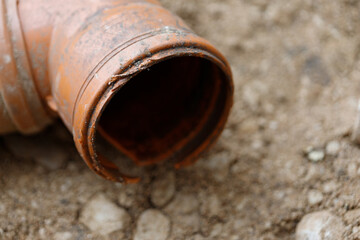 Damaged Orange Pipe on Soil