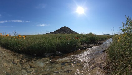 Clear sky view featuring a roadside stone pile, showcasing erosion risk