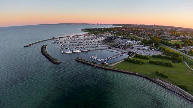 Aerial sunset view of Eg&aring; Marina with docks, sailboats, and shoreline along the Danish coast