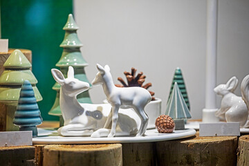 Porcelain figurine of a deer and fawn surrounded by Christmas trees. Preparing for Christmas.