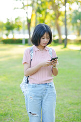 A young woman listens to music on her phone. An Asian woman stretches after sitting for a long time.