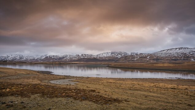 Icelandic Snaefellsnes scenery with snow-covered mountains and a tranquil lake, showcasing seasonal change