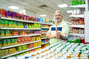 Indian man showing thumps up at super shop.