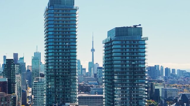 Spectacular panoramic drone view of modern Downtown skyscrapers and Lake Ontario against blue sky in Toronto, Ontario, Canada.