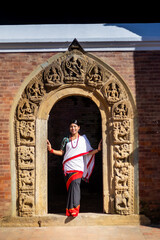 Obraz premium Nepali Newari Girl in Traditional Attire at the Stone Carved Gate, Patan Durbar Square