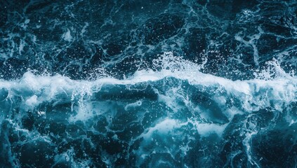 Fototapeta premium Ocean surface displaying waves, foamy splashes, and bubbles amid high surf against a blue abstract background.