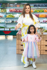 Fototapeta premium Indian woman and little girl showing thumps up at super shop