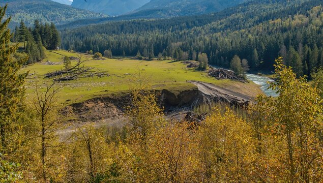 Landslide disrupted a vibrant green meadow in a valley, erosion risk
