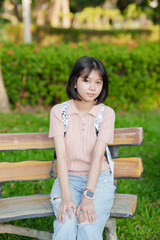 A young woman strolls through the park on her day off.