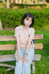 A young woman strolls through the park on her day off.