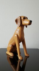 Wooden Dog Sculpture on a Black Surface with Reflection.