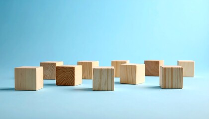 Several wooden cubes are arranged on a light blue surface with soft lighting. The cubes vary in wood grain, creating subtle visual interest