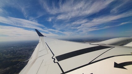 Obraz premium View from Airplane Window with Wing and Blue Sky