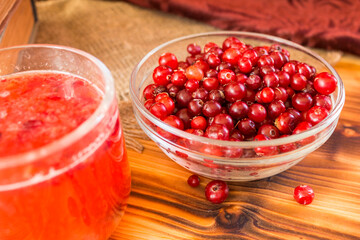 Ripe organic cranberries on rustic wooden table. Autumn harvest and healthy nutrition concept. Natural red berries background for seasonal design, countryside lifestyle and eco food theme.