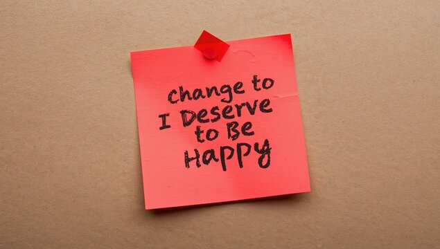 Red sticky note affixed to wallpaper with handwritten affirmation, promoting positive self-talk and self-belief