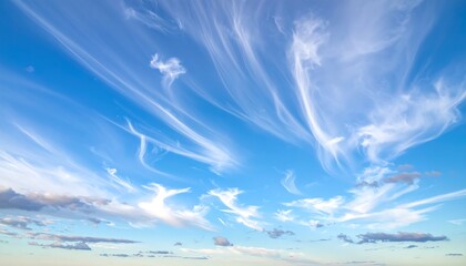 Serene view of a bright blue sky adorned with wispy, streaky cirrus clouds. Some fluffy clouds are scattered along the horizon