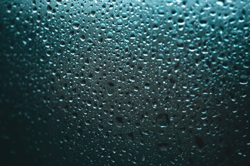 Fototapeta premium Close-up of raindrops on a glass surface outside during a summer shower
