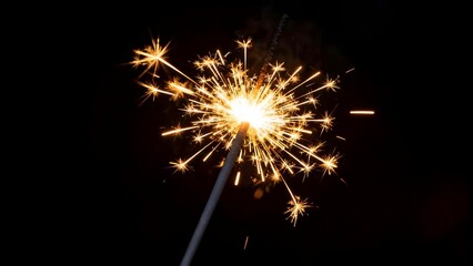 A festive sparkler glowing brightly against a dark backdrop, with golden sparks radiating outward, perfect for capturing the joyful, celebratory spirit of the New Year.