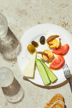 White plate on a table with meze for ouzo