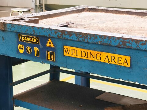 Welding area safety signage in industrial workshop - Powered by Adobe