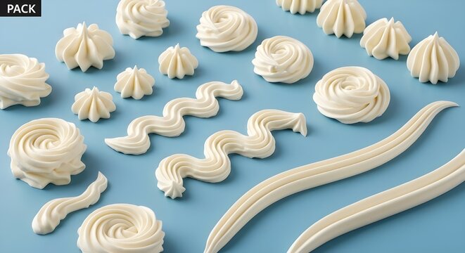 Various piped vanilla icing, frosting, and whipped cream decorations on blue background
