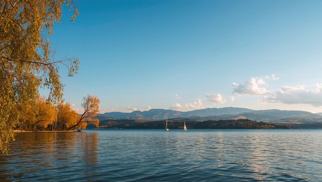 Lake Pamvotis surrounded by lush greenery, showcasing seasonal change