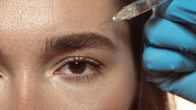 Forehead injection as aesthetic correction by professional dermatologist. Concept of dermatology, personal branding, and youthful balance in beauty and medical care.