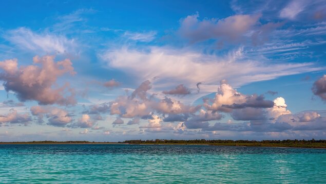 Vibrant clouds drift above the serene water, reflecting the beauty of nature