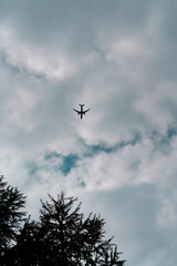 Silhouette of an airplane flying directly overhead in a deep dark blue dramatic sky. Minimalistic scene with strong contrast and cinematic atmosphere.
