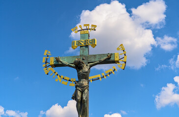 Bronze cross with the crucified figure of Jesus Christ on the Charles Bridge in Prague, Czech...